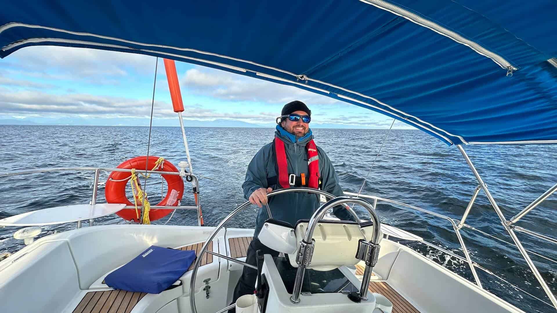 Man driving boat on open water. Safe sailing with life vest. Boat trip adventure. Landing page image.